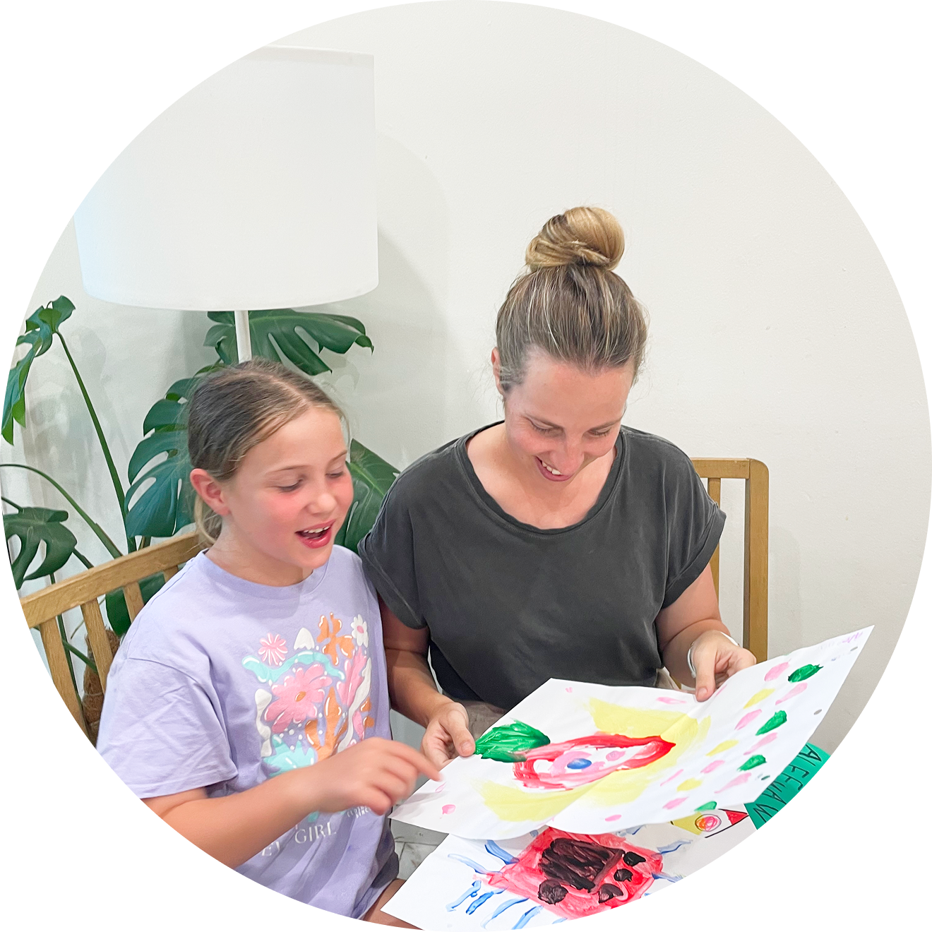 A mother and child gathering children's artwork